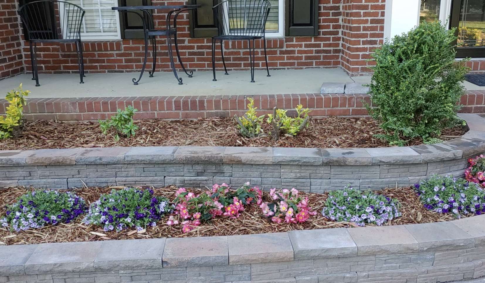 Front planting beds behind a two-tier block retaining wall